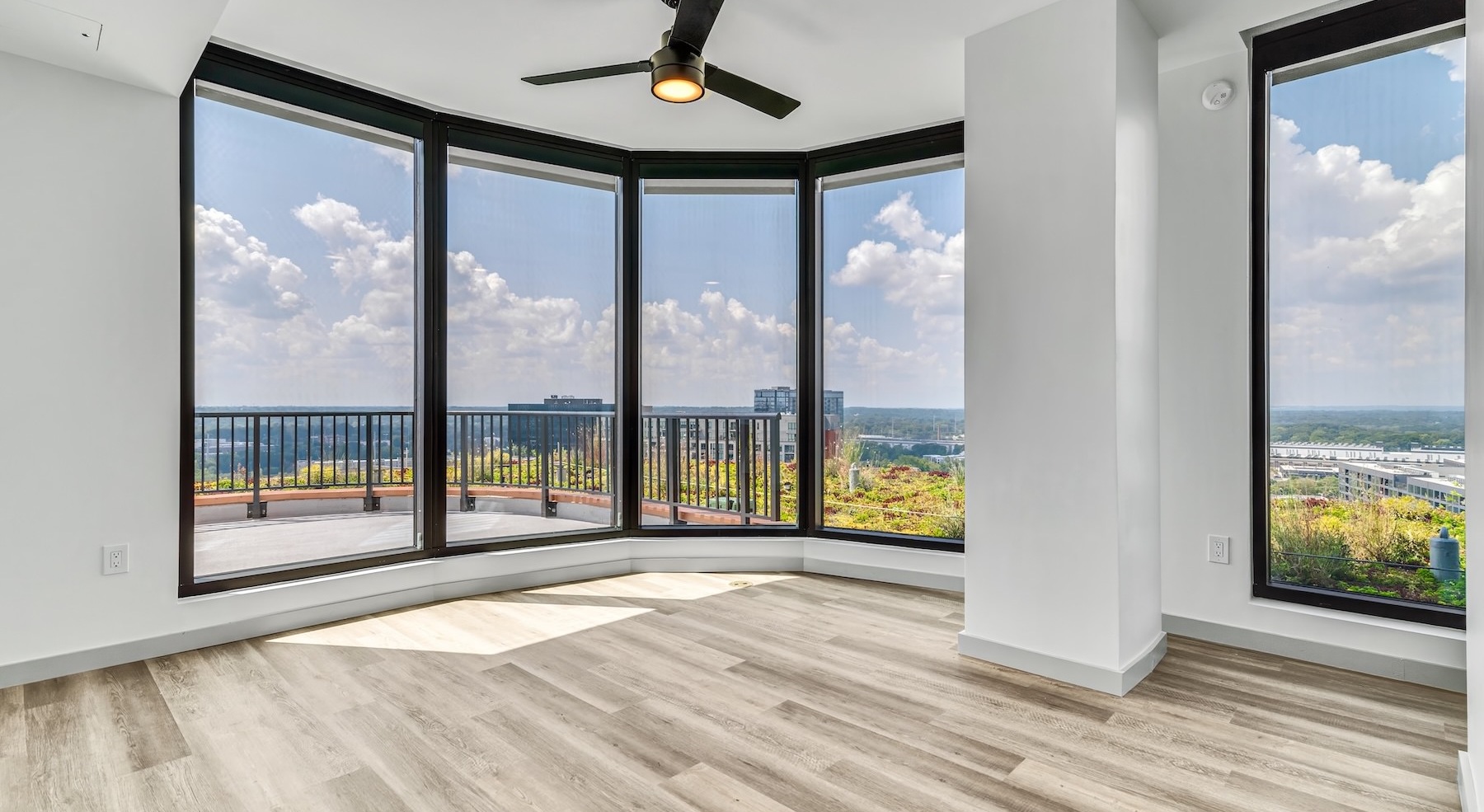 unfurnished room with fan and large windows