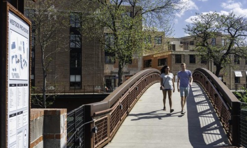 a man and woman walking on a bridge