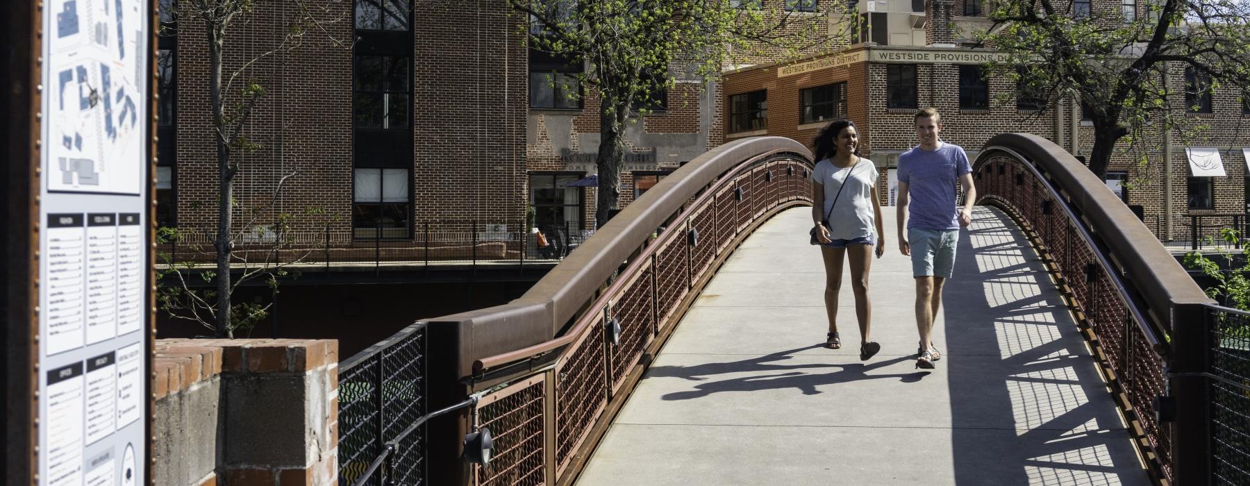 a man and woman walking on a bridge